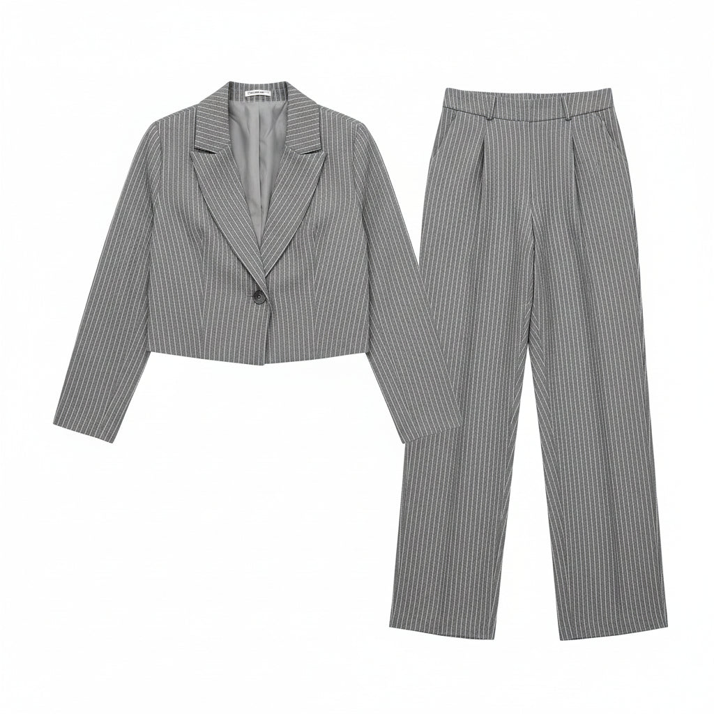 Woman wearing a gray pinstripe suit with a white top outdoors.