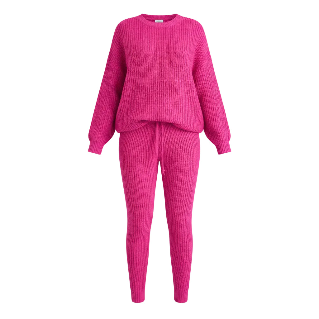 Person wearing a bright pink ribbed sweater and pants set, standing in a living room.