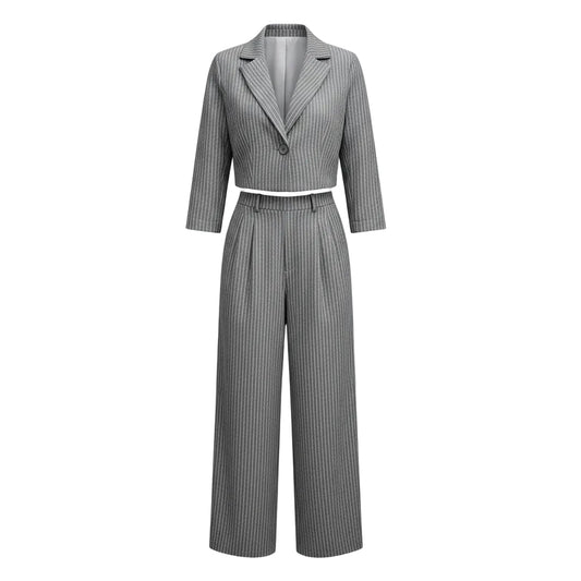 Woman wearing a gray pinstripe suit with a white top in an urban setting.