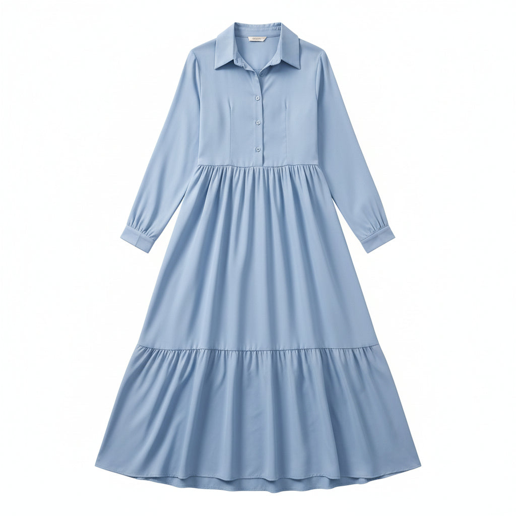 Woman wearing a light blue dress with long sleeves in a room.