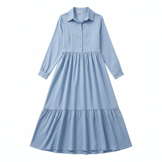 Woman wearing a light blue dress with long sleeves in a room.