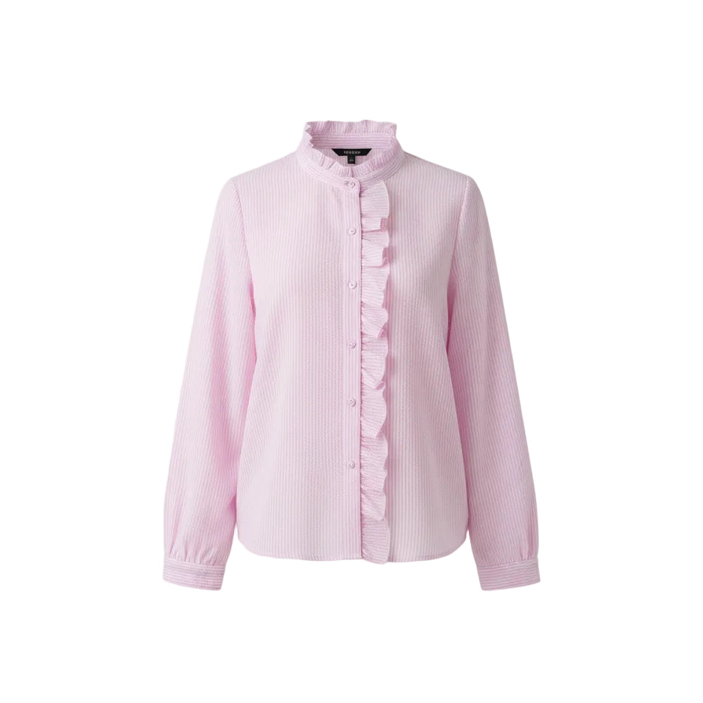 A woman wearing a light pink waffle-textured button-up blouse with ruffle trim, tucked into light-wash blue jeans with a brown belt.