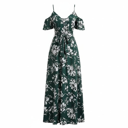 Woman wearing a green floral dress sitting on a wicker chair.