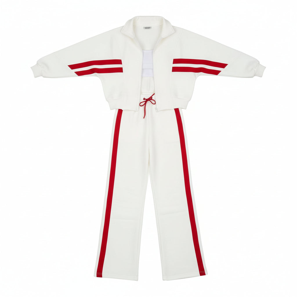 Person wearing a white and red tracksuit in an indoor setting with a plant and staircase.