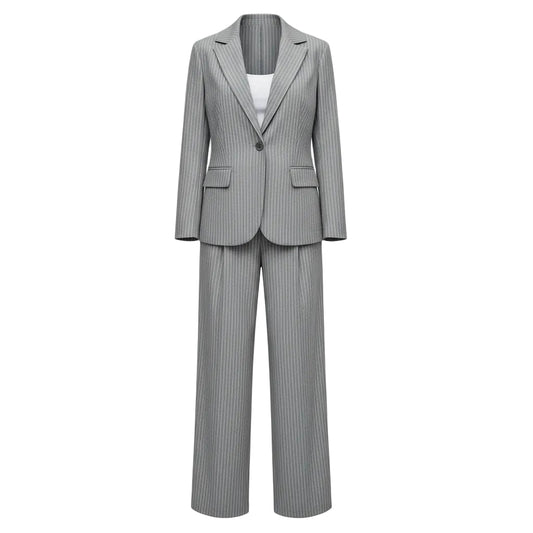 Person wearing a gray pinstripe suit with a white top outdoors.